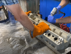 mechanics using custom fixturing made on a waterjet cutter to repair a Jaguar engine