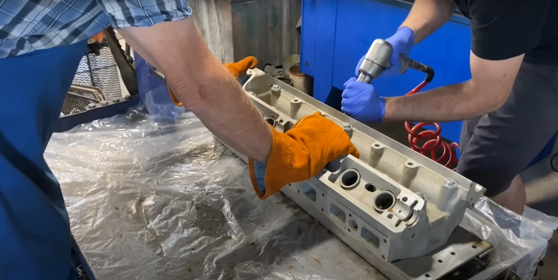 mechanics using custom fixturing made on a waterjet cutter to repair a Jaguar engine